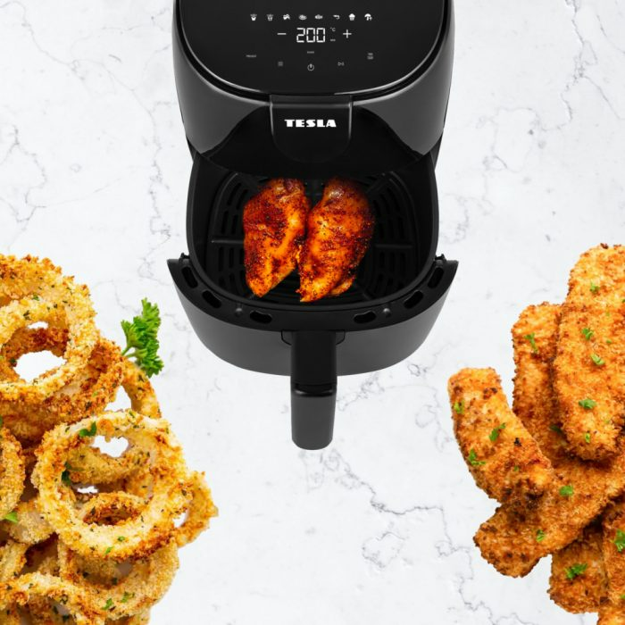 Egy légkeveréses fritőz sült ételekkel: csirkemell, hagymakarikák és sült krumpli. A kijelző 200°C-t mutat.