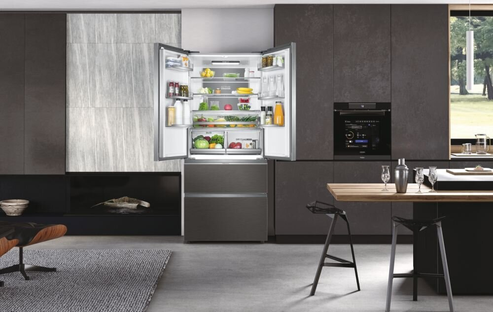 Nowoczesne wnętrze kuchni z lodówką z otwartymi drzwiami, pełną jedzenia.
