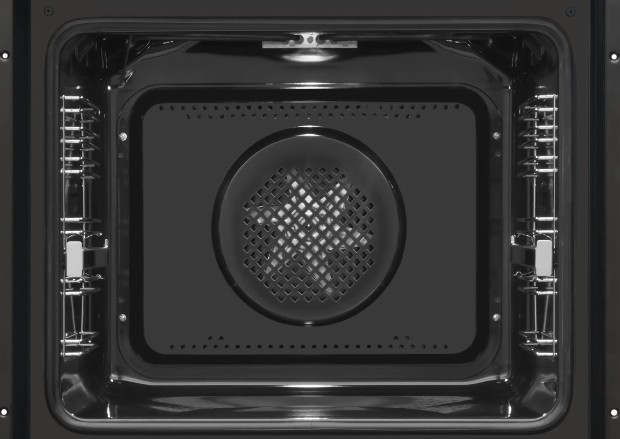 Interior de un horno negro, con rejillas, ventilador y ventilación circular.