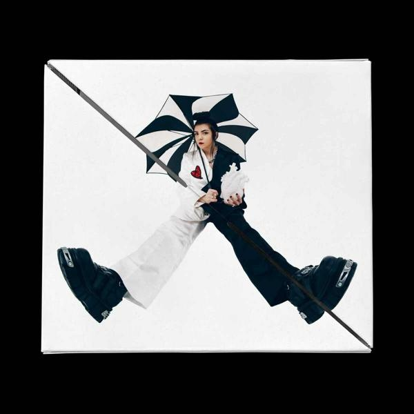 Une personne en costume noir et blanc tient une lance et un parapluie noir et blanc.