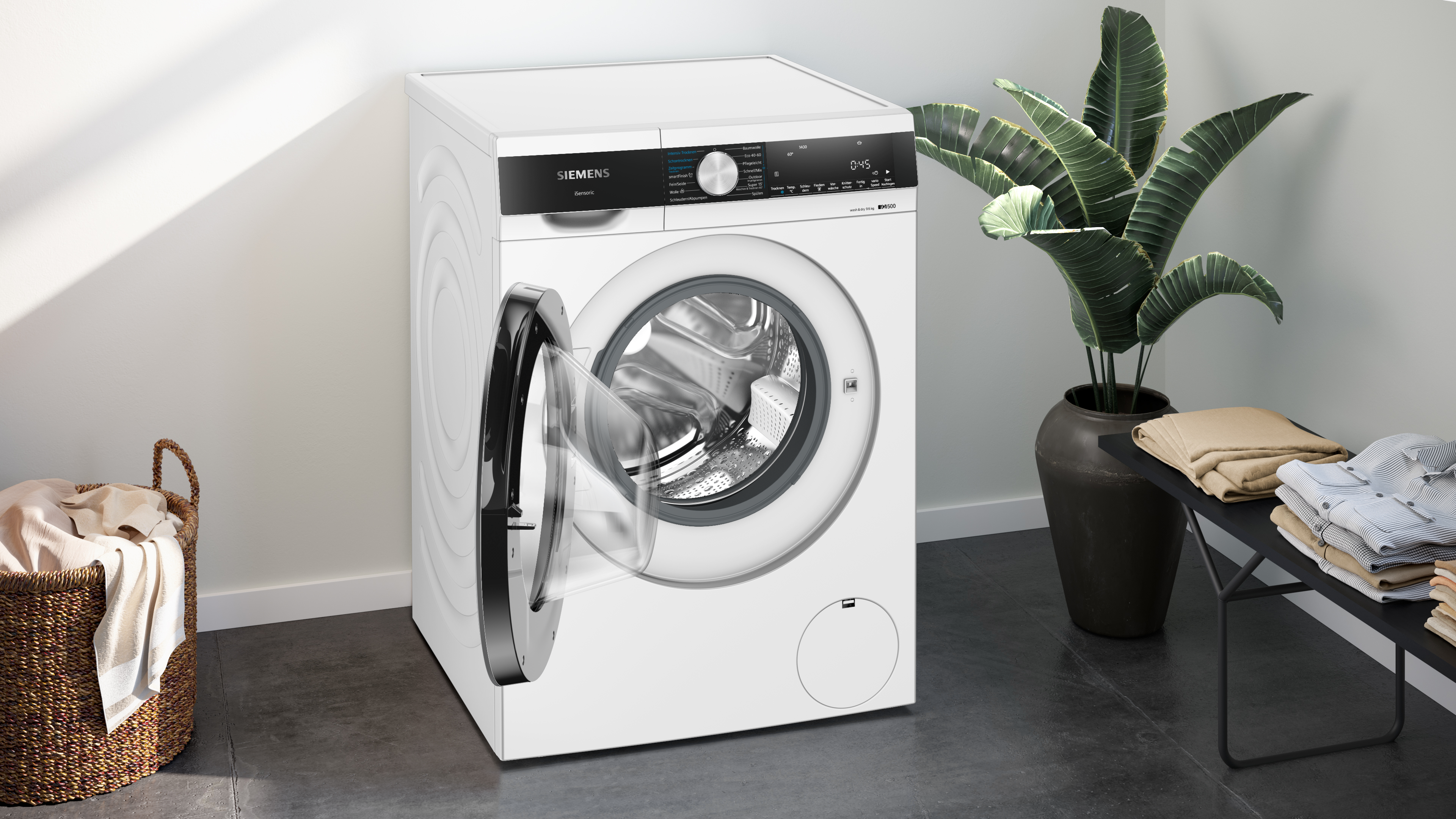 Weiße Siemens Waschmaschine mit offener T ür. Ein Korb und Gegenstände sind in der Nähe.