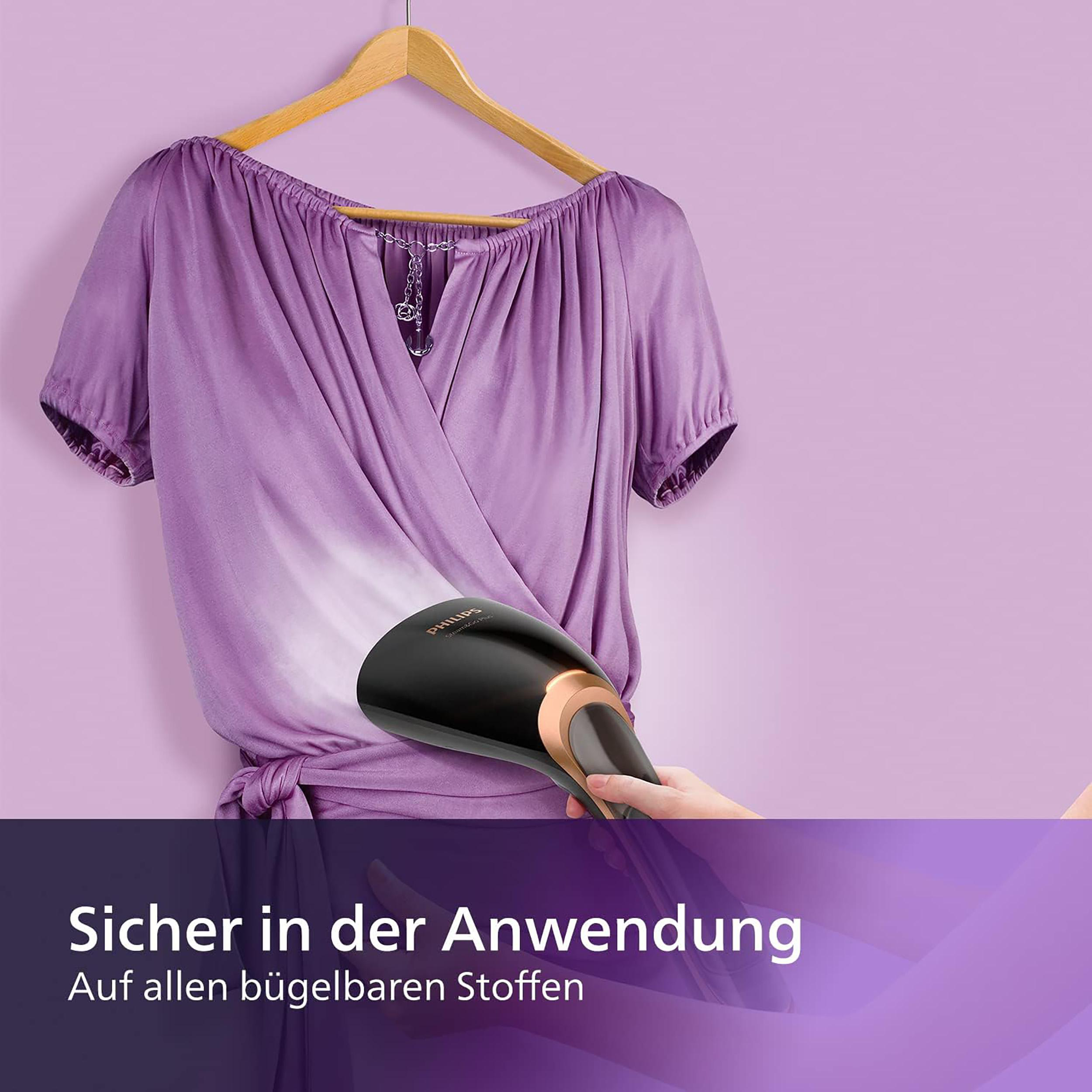 Eine violette Bluse wird mit einem schwarzen und roségoldenen Steamer gedämpft.