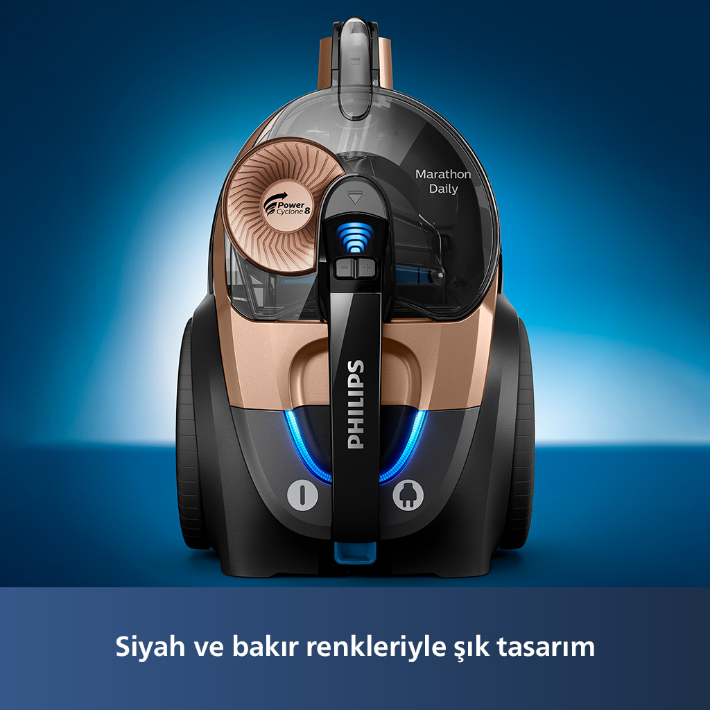 PHILIPS markası olan siyah ve bakır renkli bir elektrikli süpürge. Arka plan mavi.