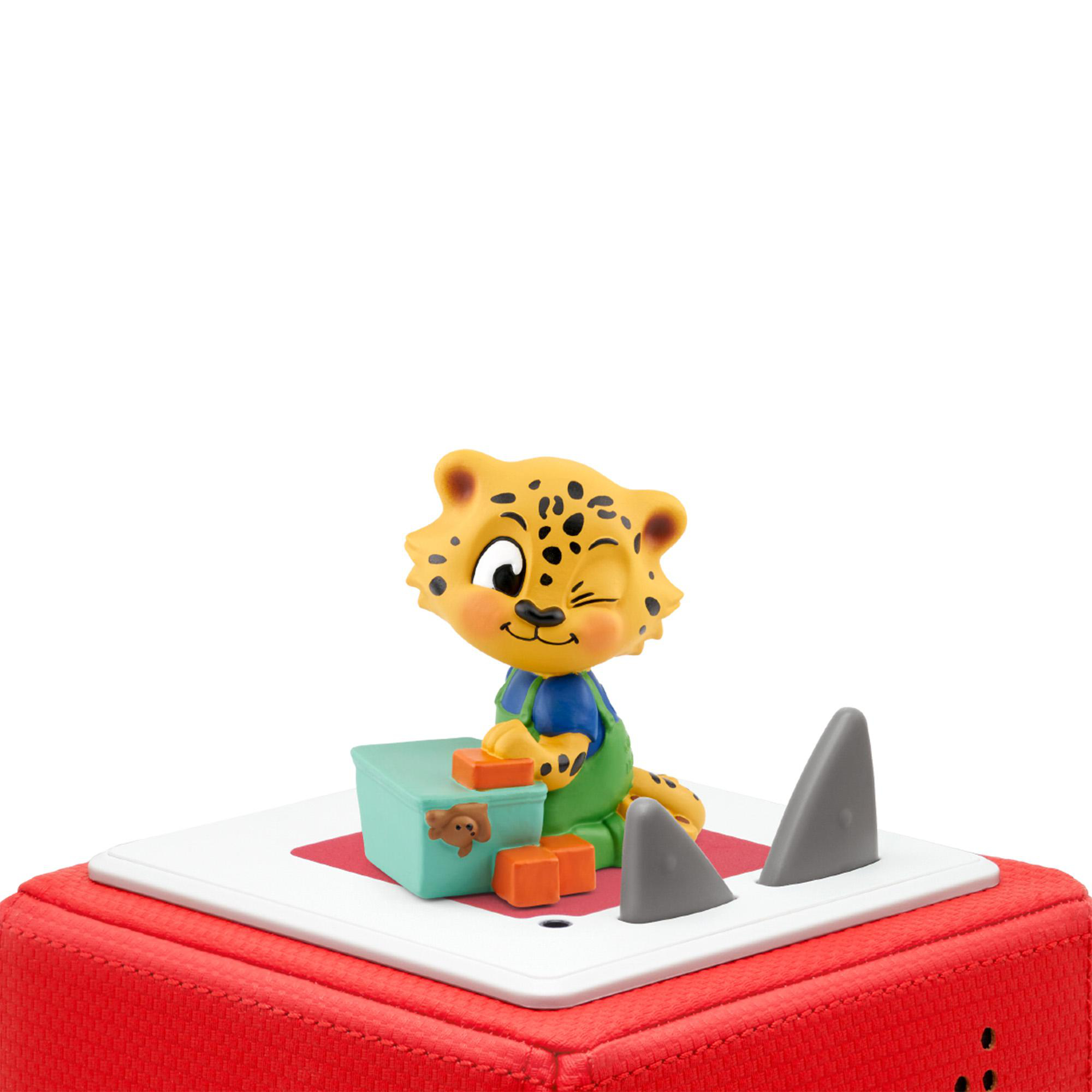 Spielzeugfigur eines Leoparden mit Blöcken auf einem roten Würfel. Weißer Hintergrund.