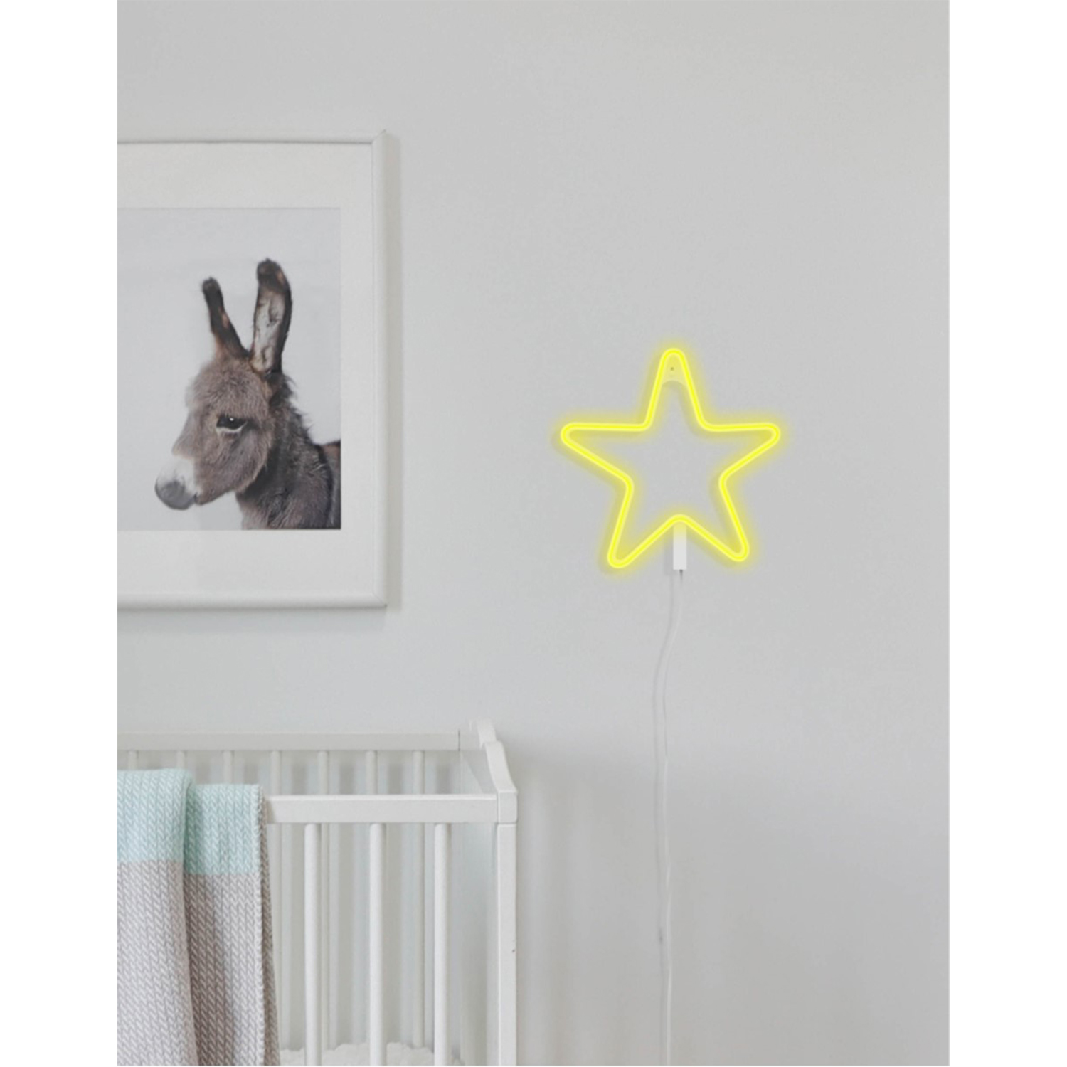 Una cameretta bianca con un'immagine di asino incorniciata e una luce a stella al neon gialla.