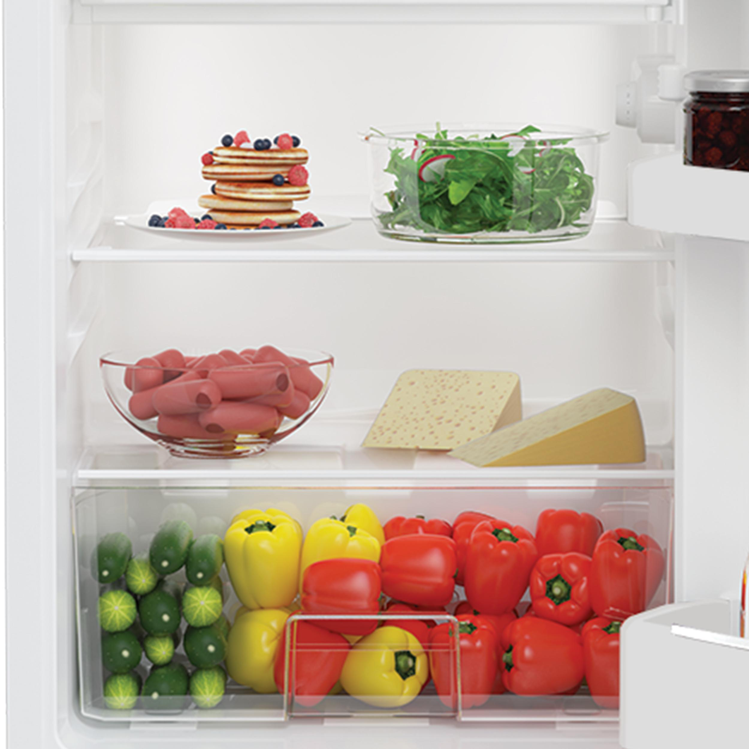 Ein Kühlschrank voller Lebensmittel, einschließlich Gemüse, Käse und Pfannkuchen.