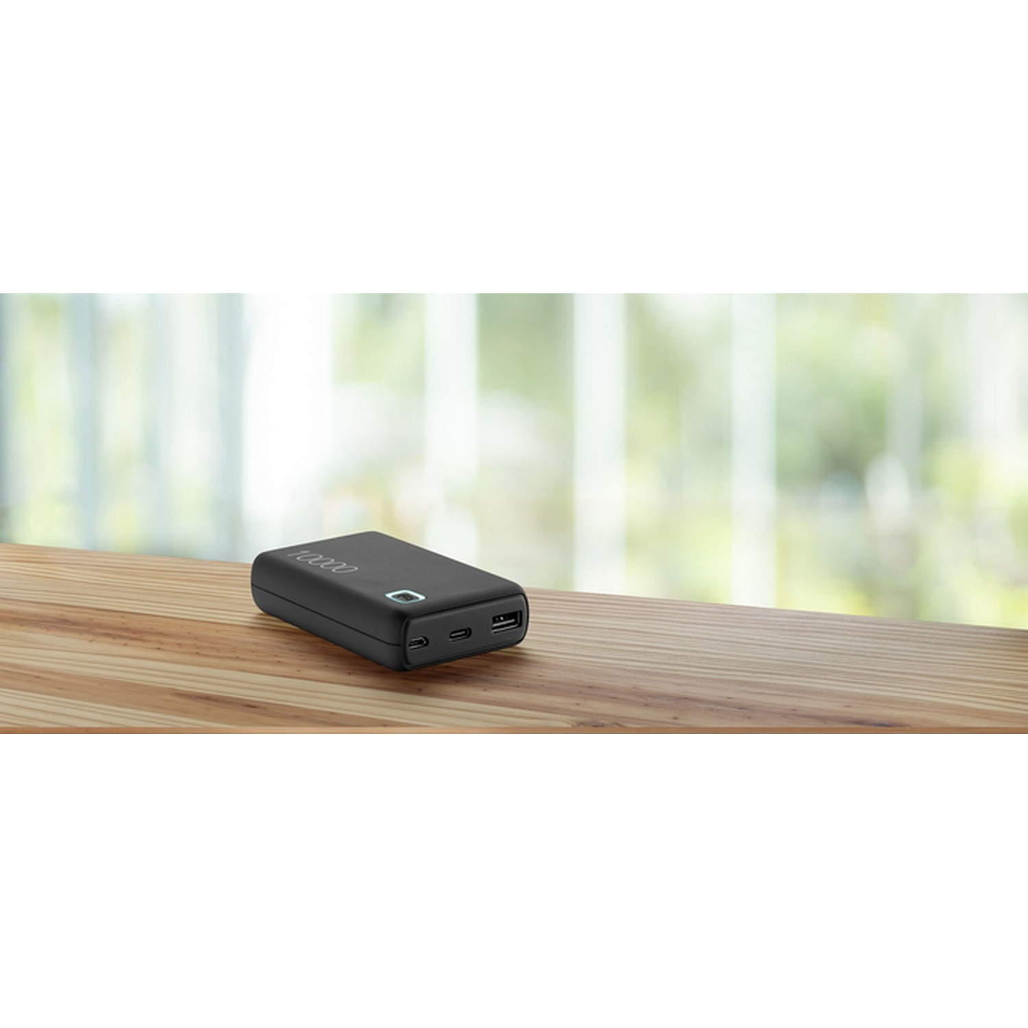 Zwarte powerbank op een houten tafel. Toont 10000 bovenaan en poorten aan de zijkant.