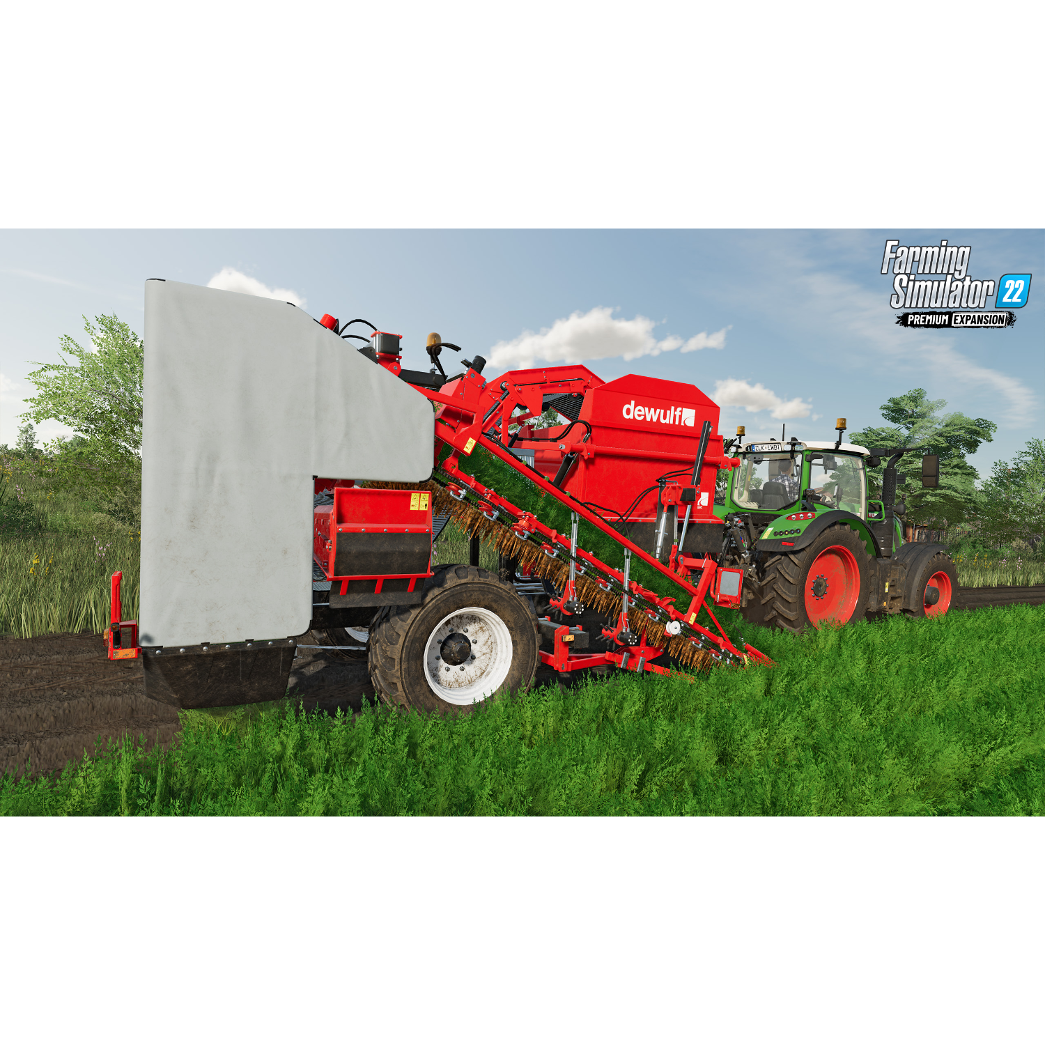 Een grote rode landbouwmachine in een veld, met een groene tractor ernaast.