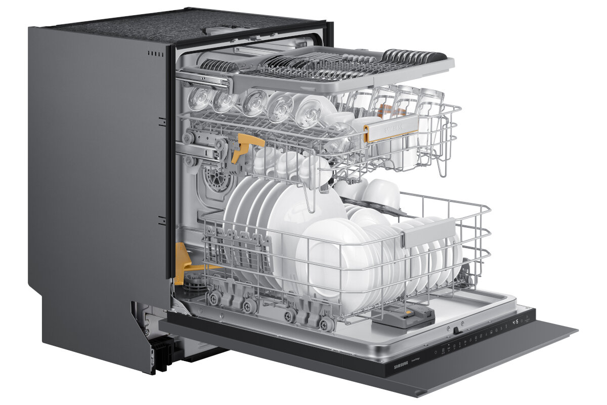 Zmywarka z otwartymi drzwiami, załadowana naczyniami, szklankami i przyborami. Jest srebrna.