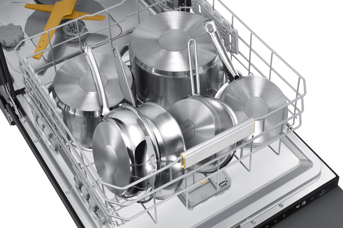 Wnętrze zmywarki z różnymi garnkami i patelniami ze stali nierdzewnej. Znajdują się w koszu zmywarki.