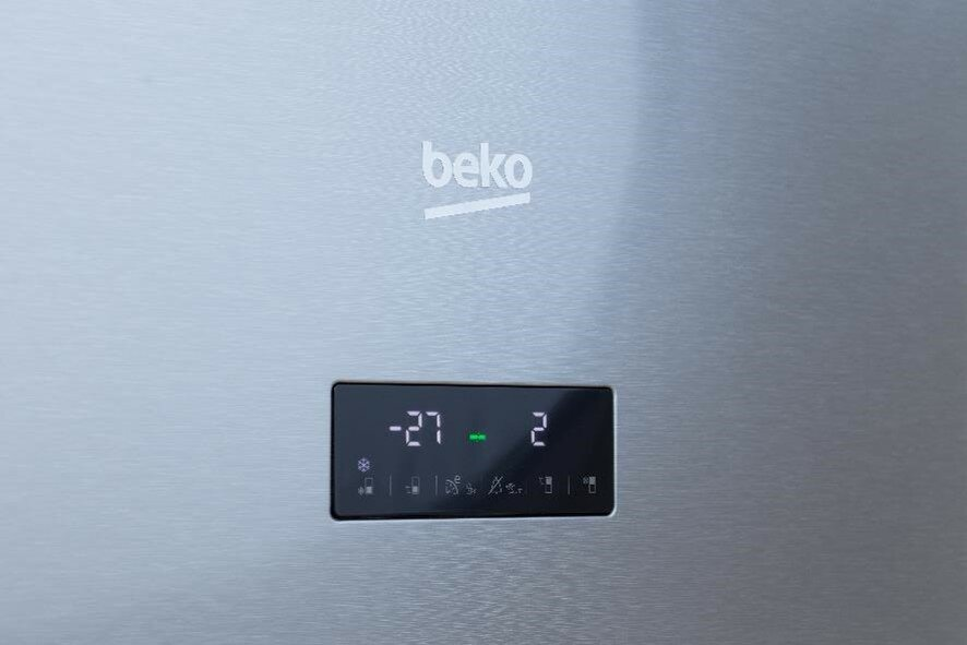 Wyświetlacz zamrażarki Beko pokazuje -27 i 2. Cyfry i symbole są zielone na srebrnej powierzchni.