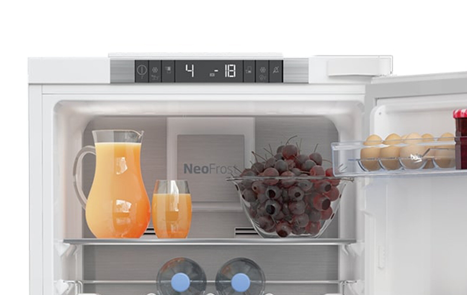 Wewnątrz lodówki: sok, szklanka i miska wiśni.