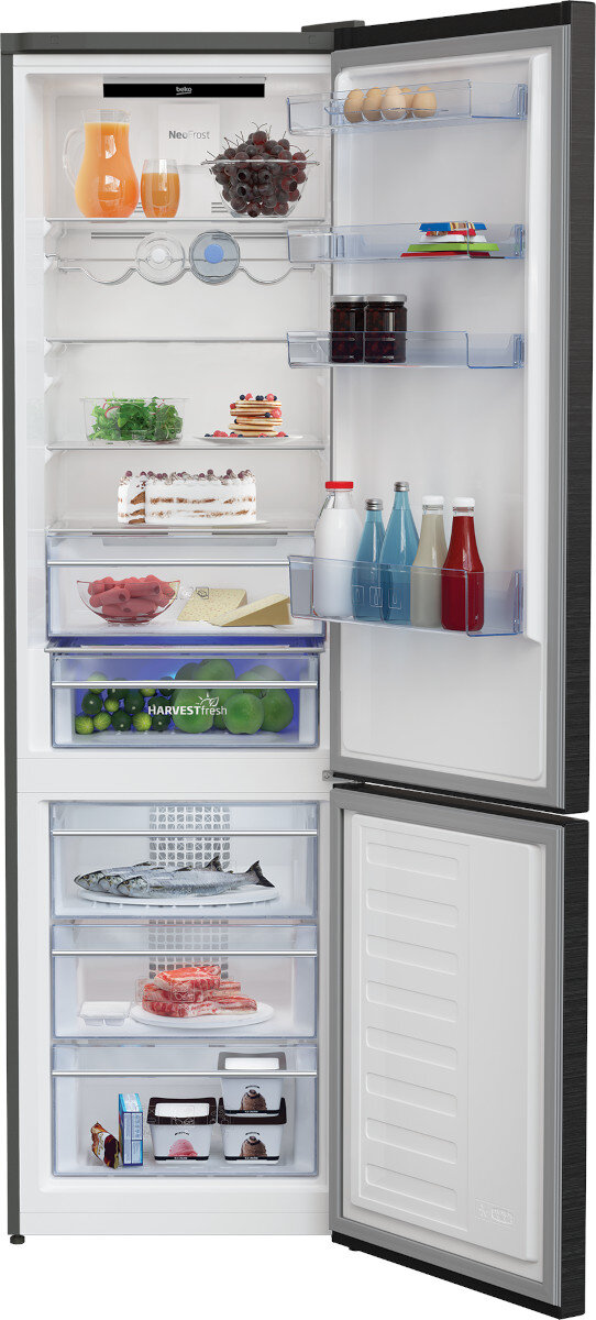 Otwarta lodówka wypełniona jedzeniem, z częściowo otwartą zamrażarką.