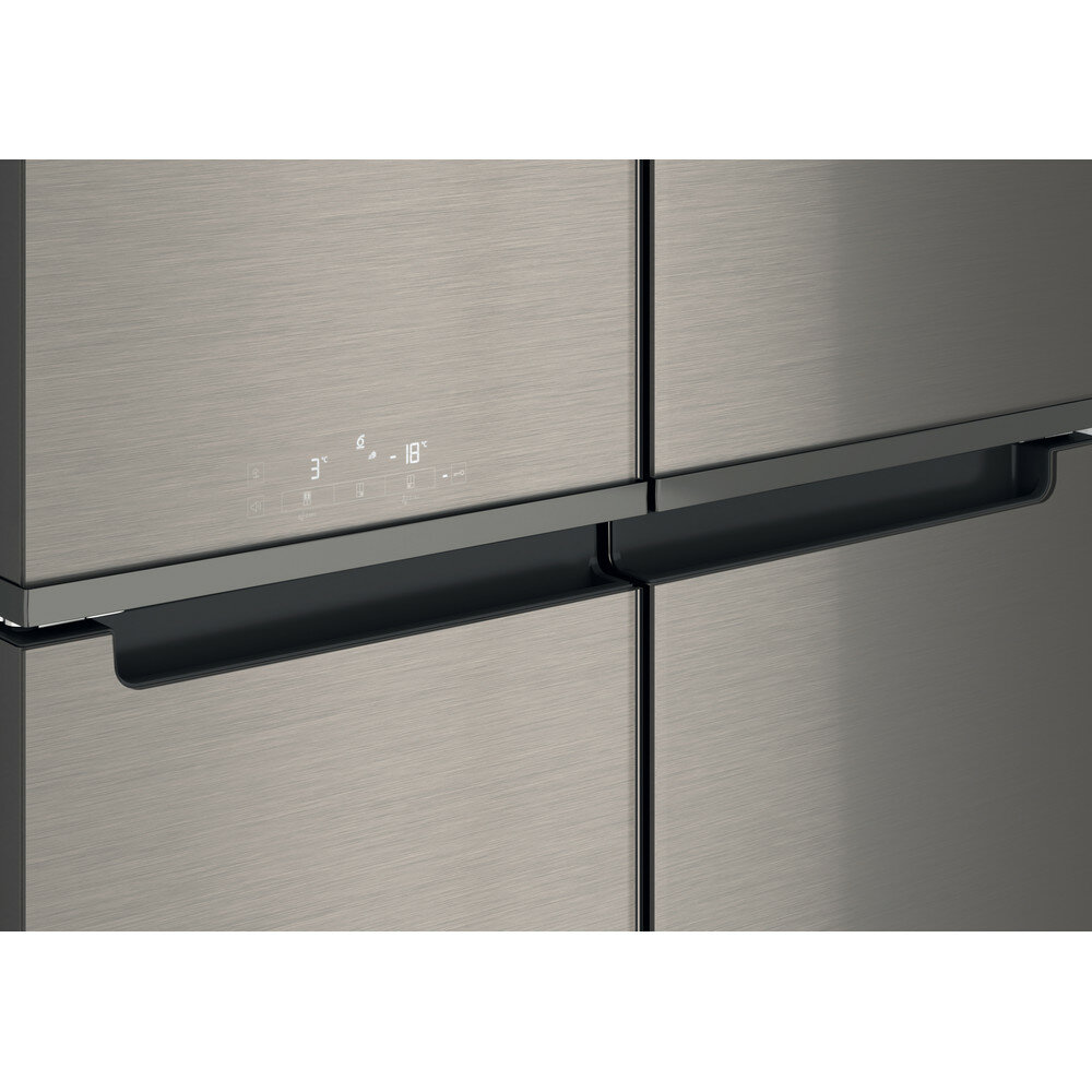 Zbliżenie na nowoczesne srebrne drzwi lodówki z wpuszczonym uchwytem i wyświetlaczem cyfrowym.