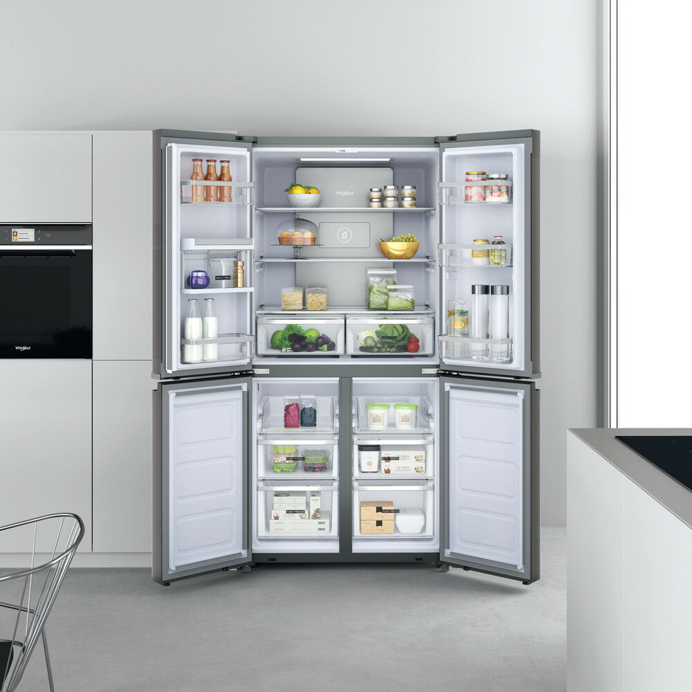 Otwarta lodówka, prezentująca wewnętrzne przechowywanie z produktami spożywczymi.