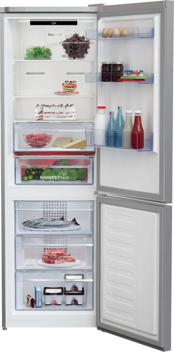 Otwarta lodówka z półkami pełnymi jedzenia. Zawiera warzywa, owoce i różne pojemniki. Czyste wnętrze.