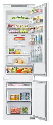 Biała lodówka jest otwarta, ukazując półki pełne produktów spożywczych, takich jak owoce, warzywa, napoje i gotowe posiłki. Drzwi są uchylone.