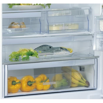 Wnętrze lodówki z wieloma półkami. Żółta papryka, ryby i inne produkty spożywcze są widoczne.