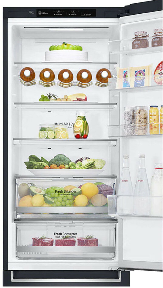 Otwarta lodówka z różnymi produktami spożywczymi na półkach, w tym owoce i warzywa.