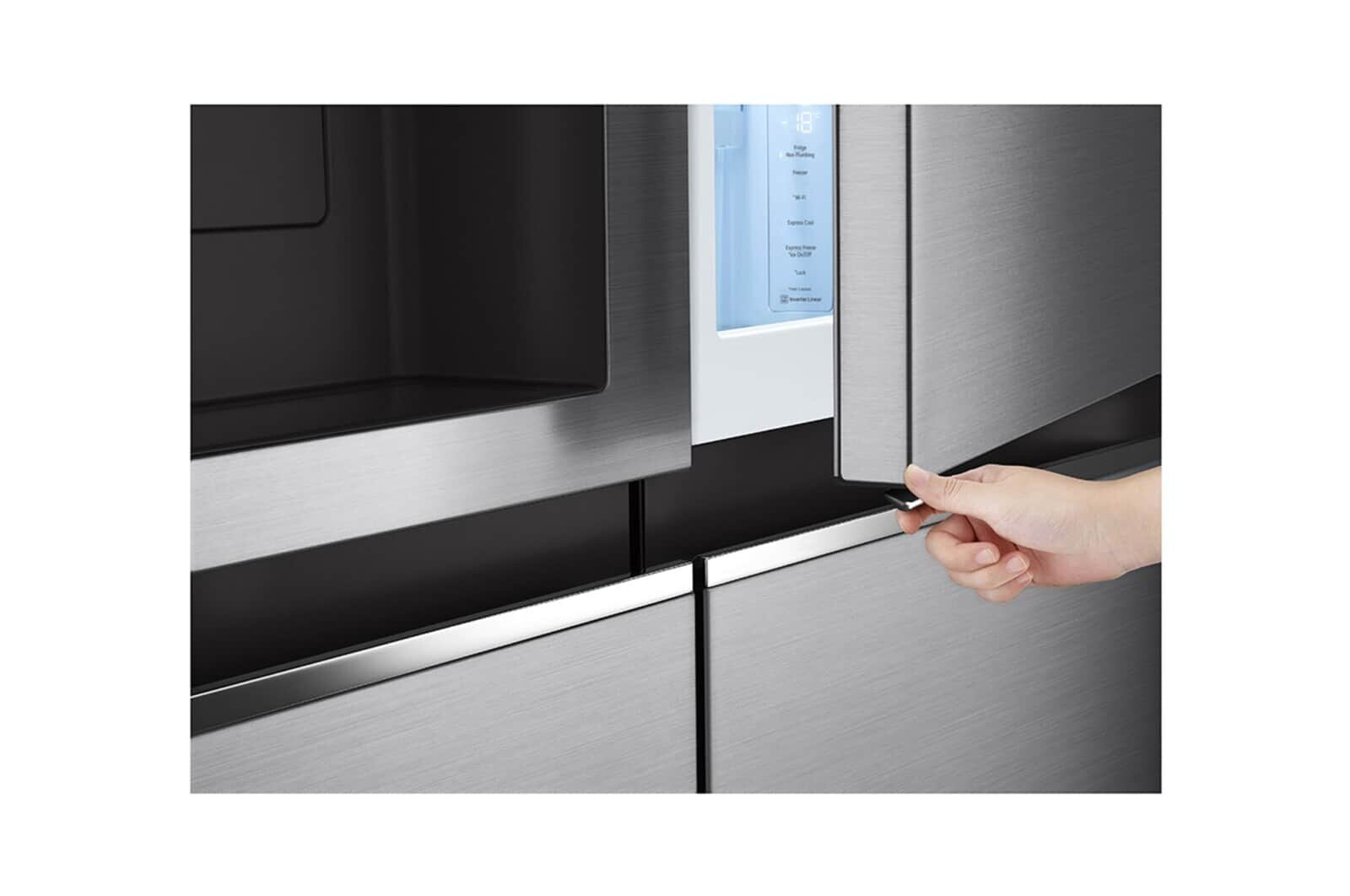 Ręka otwierająca ciemnoszare drzwi lodówki, odsłaniając niebiesko oświetlone wnętrze i wyświetlacz cyfrowy.