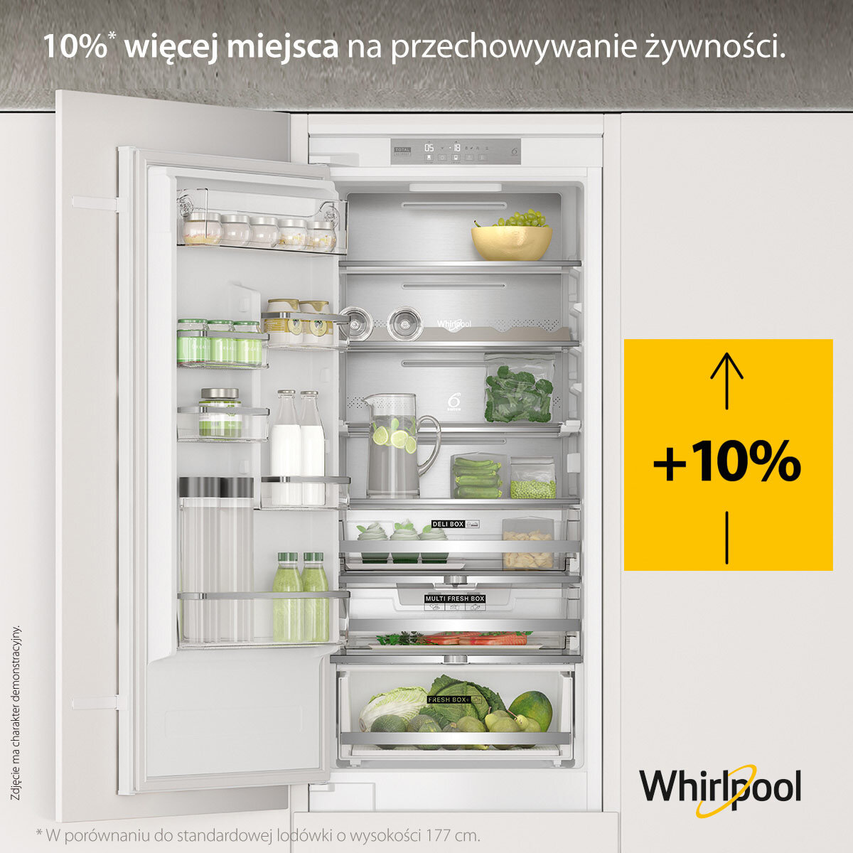 Otwarta lodówka z półkami i szufladami. Żółte pudełko ze znakiem +10% po prawej stronie.