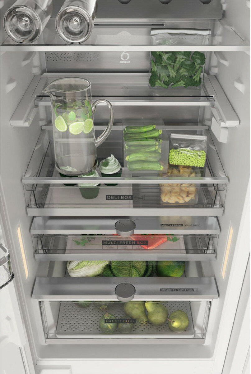 Wnętrze lodówki z różnymi produktami spożywczymi. Są półki i szuflady z jedzeniem.