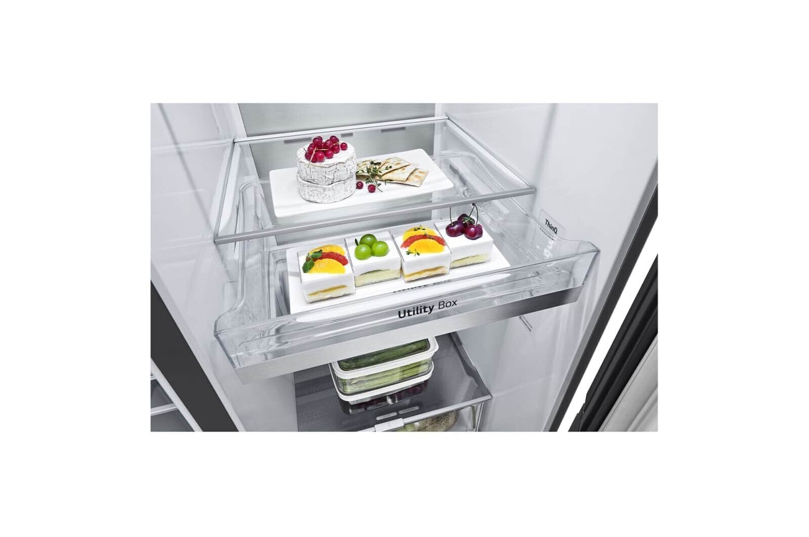 Wnętrze lodówki z tacami na żywność. Górna taca z deserem. Środkowa taca z ciastami. Dolna taca z warzywami.