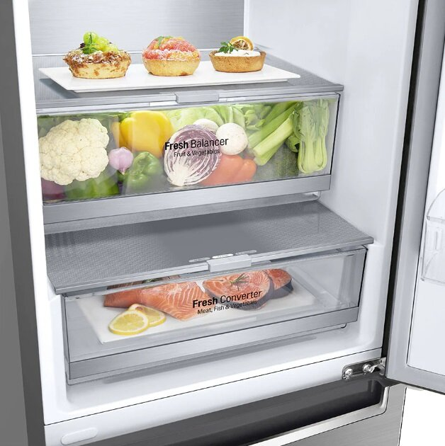 Lodówka z trzema szufladami, wypełniona jedzeniem.