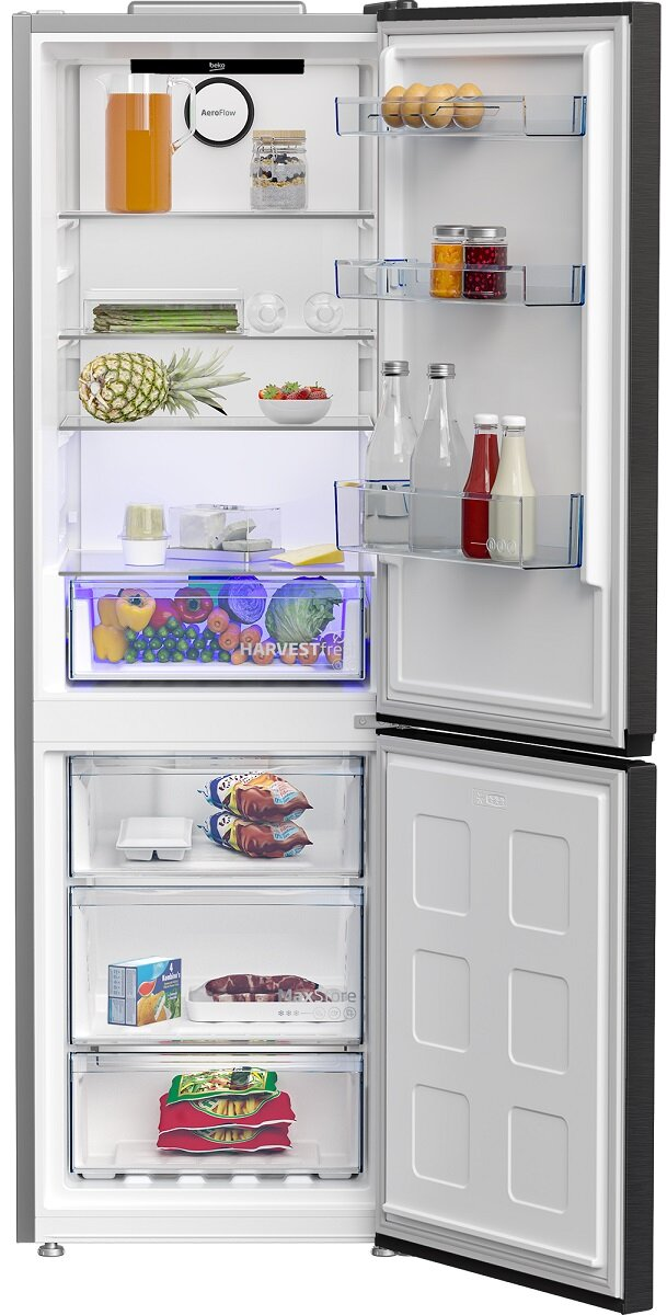 Otwarta lodówka wypełniona jedzeniem i półkami, w tym świeżymi produktami.