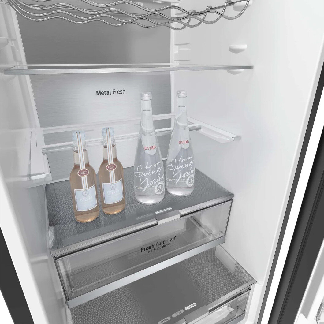 Wnętrze lodówki z dwiema butelkami wody i dwiema małymi różowymi butelkami.