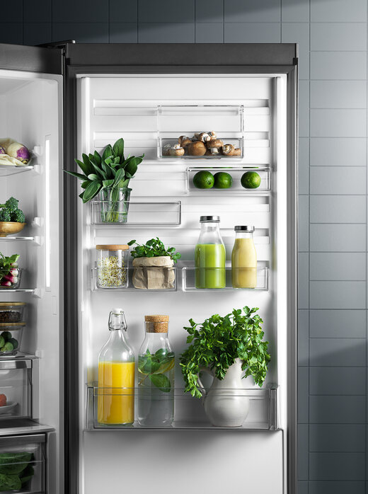 Lodówka z otwartymi drzwiami, pokazująca półki i szuflady w środku.