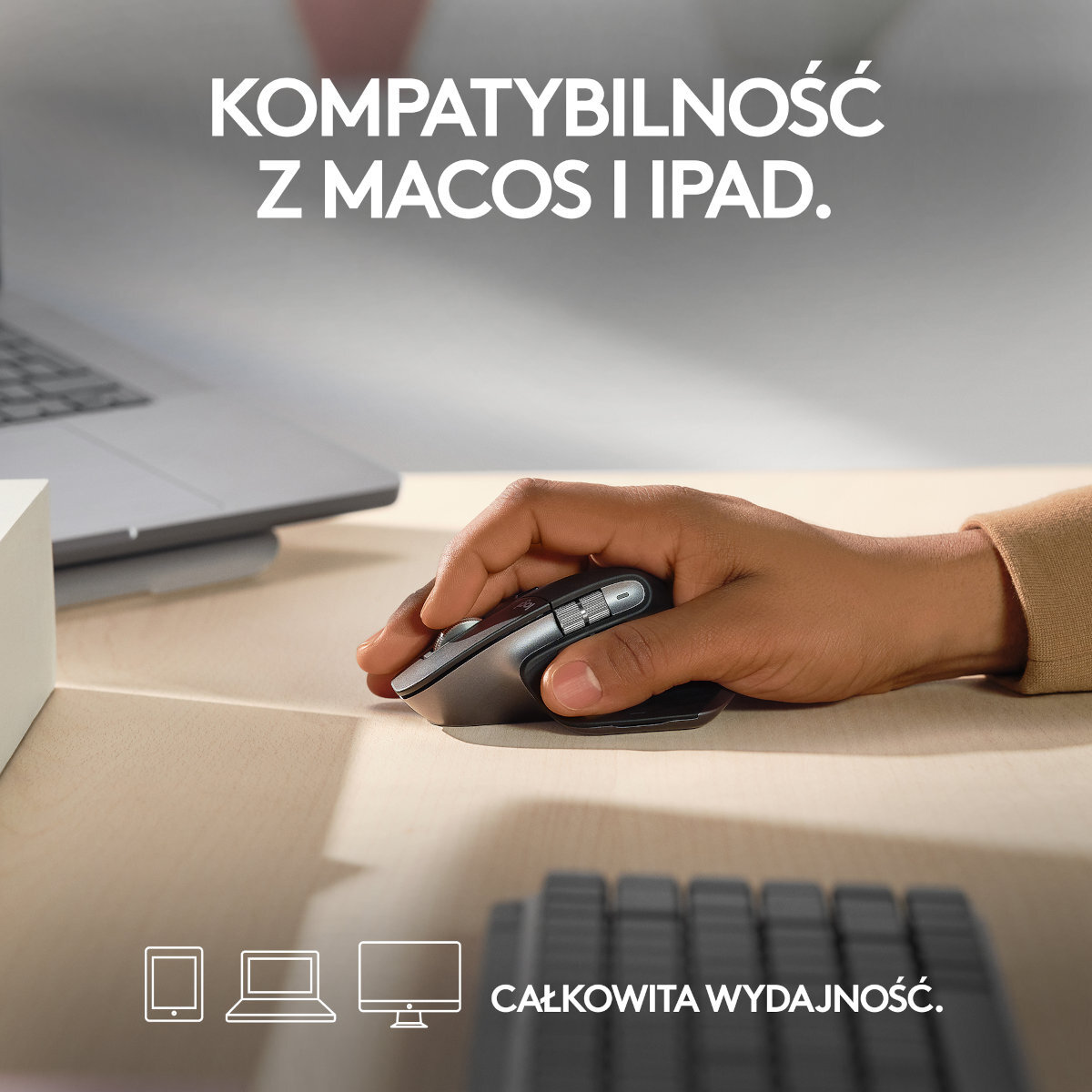 Dłoń używająca czarno-szarej myszy na biurku. Tekst: Kompatybilność z MacOS i iPad.