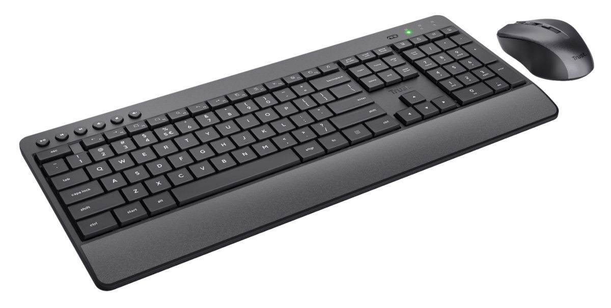 Czarna klawiatura i mysz Trust. Klawiatura ma wiele klawiszy. Mysz jest ciemna.