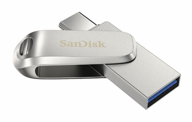 Srebrny pendrive SanDisk z niebieską końcówką złącza USB.