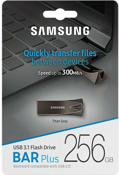Pamięć flash USB Samsung w opakowaniu, z tekstem. Laptop w tle.