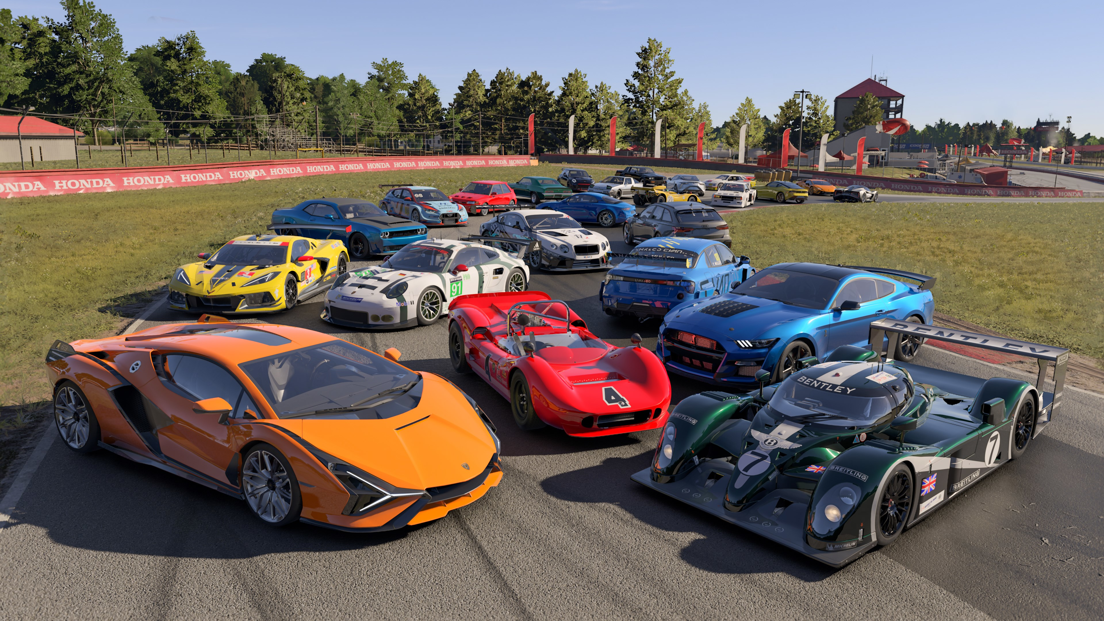 Groupe de voitures de course sur un circuit, dont une Lamborghini et une Bentley.