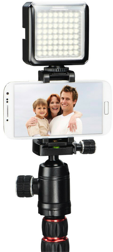 Smartfon na statywie z światłem, pokazujący zdjęcie rodzinne, na białym tle.