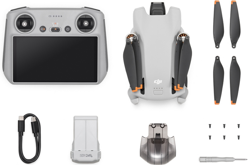 Dron y accesorios. El dron es gris, incluye controlador, batería, hélices y destornillador.