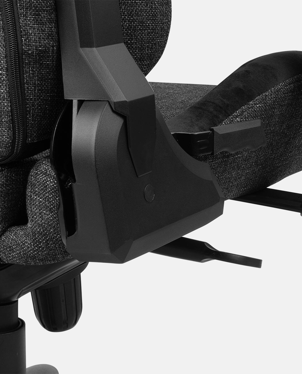 Primer plano del reposabrazos y mecanismo de ajuste de una silla negra, mostrando detalles y texturas.
