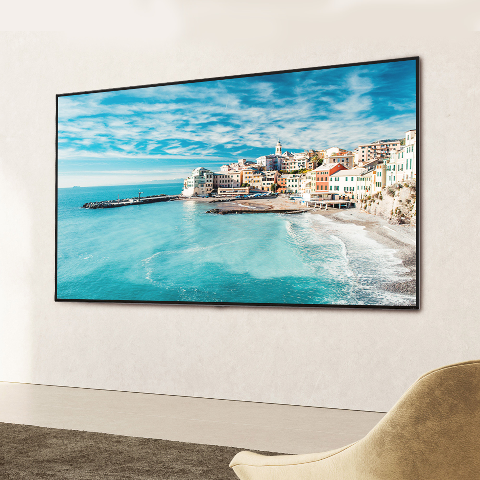 Pantalla de TV grande que muestra una escena de un pueblo costero, montada en una pared.