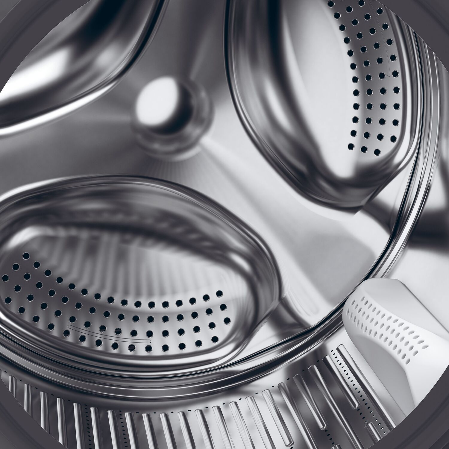 Interior de una lavadora. Tambor de metal plateado con perforaciones, dispensador de detergente blanco visible.