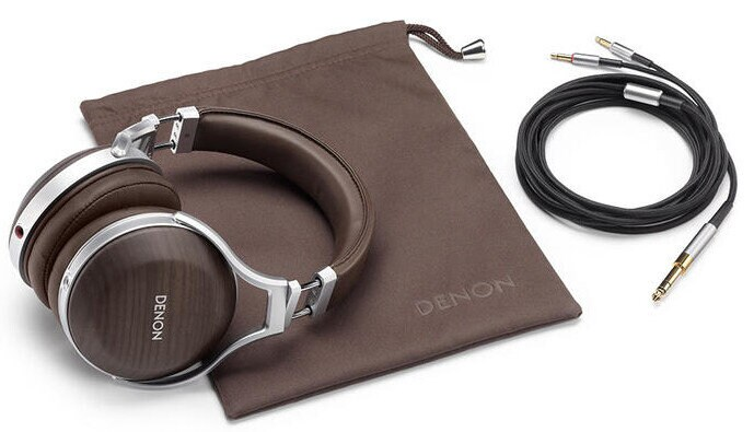 Brązowe słuchawki, kabel i etui z logo Denon na białej powierzchni. Słuchawki mają srebrne akcenty. Kabel jest czarny.
