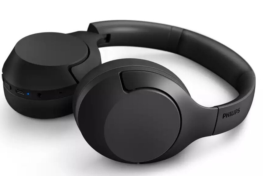 Czarne słuchawki leżące płasko na białej powierzchni. Marka "PHILIPS" jest widoczna po prawej stronie.