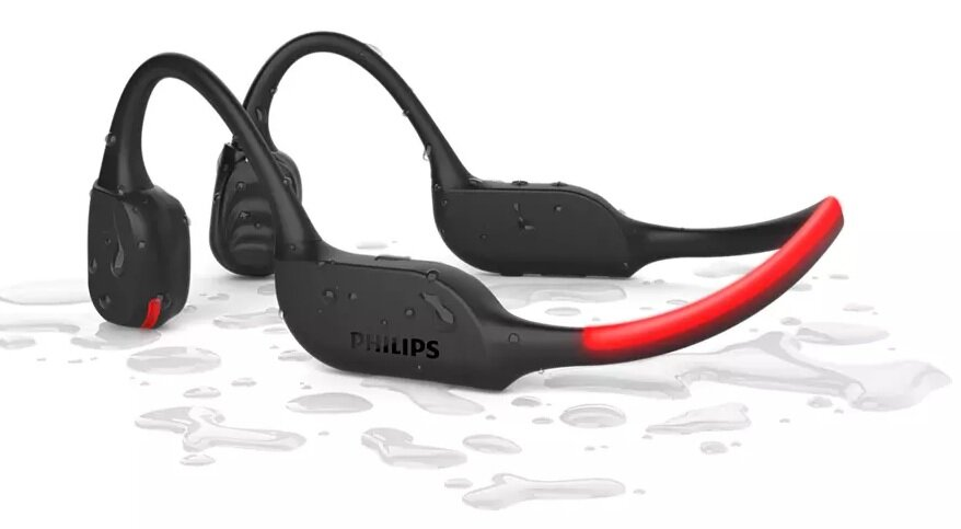 Czarne i czerwone słuchawki Philips do przewodnictwa kostnego. Są w wodzie, z kroplami wody.