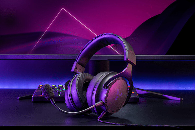 Czarny zestaw słuchawkowy do gier z mikrofonem na biurku z fioletowym i różowym tłem.