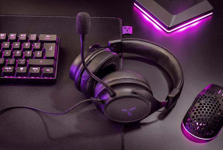 Czarny zestaw do gier. Klawiatura, mysz i zestaw słuchawkowy na podkładce. Scena oświetlona na fioletowo.