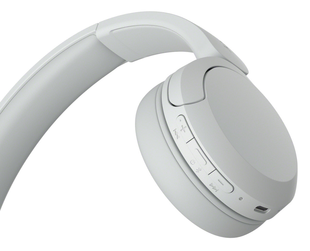 Zbliżenie białych słuchawek bezprzewodowych z przyciskami głośności i zasilania. Przyciski są czarne.