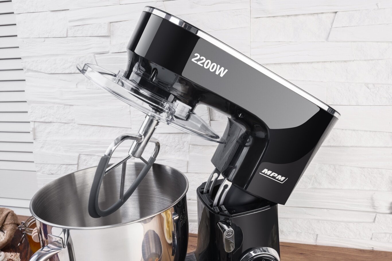 Czarny mikser kuchenny z misą ze stali nierdzewnej i trzepaczką.