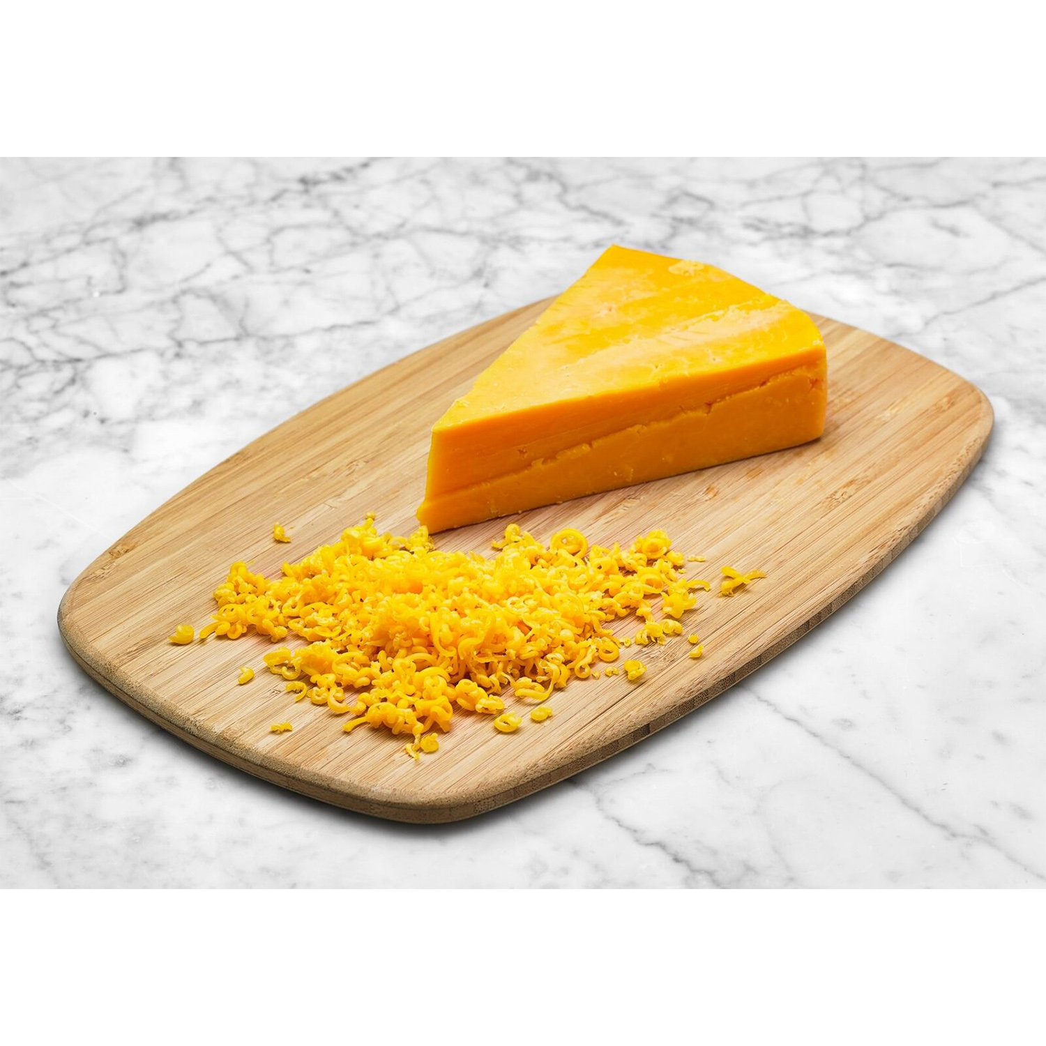 Una fetta di formaggio cheddar su un tagliere di legno.