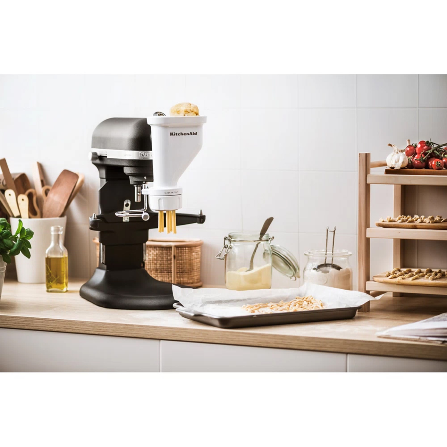 Frullatore KitchenAid con accessori su un piano di lavoro. Sono presenti altri oggetti da cucina.